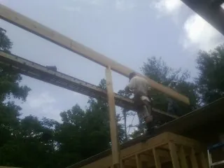 Carpenter setting a ridge beam over a new addition frame — Ice Dam Removal by Roofing Brothers in Hellertown