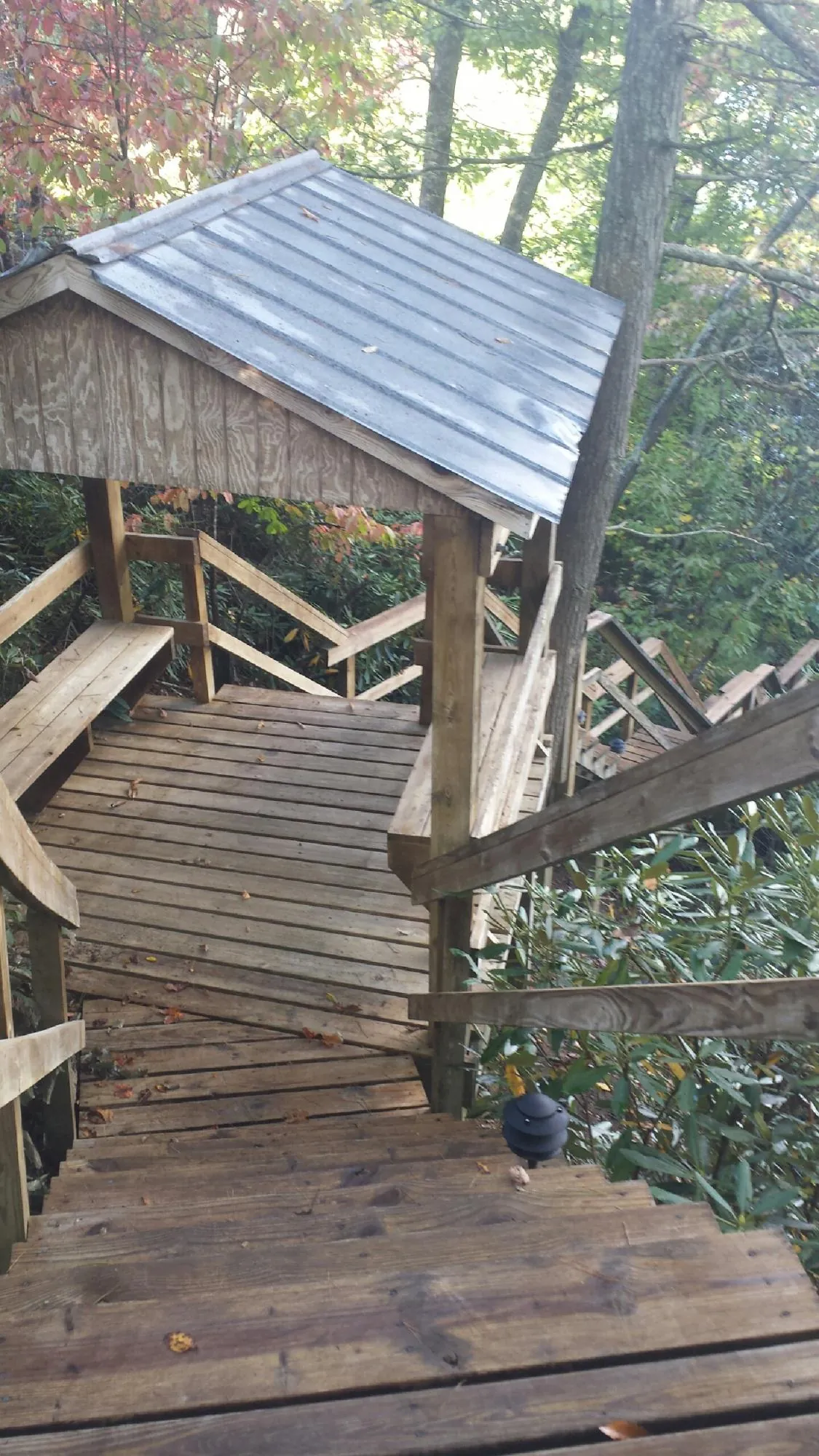 Metal roofed shelter over wooden steps on a wooded walkway — Skylight Repair & Installation work by our crew in Hellertown
